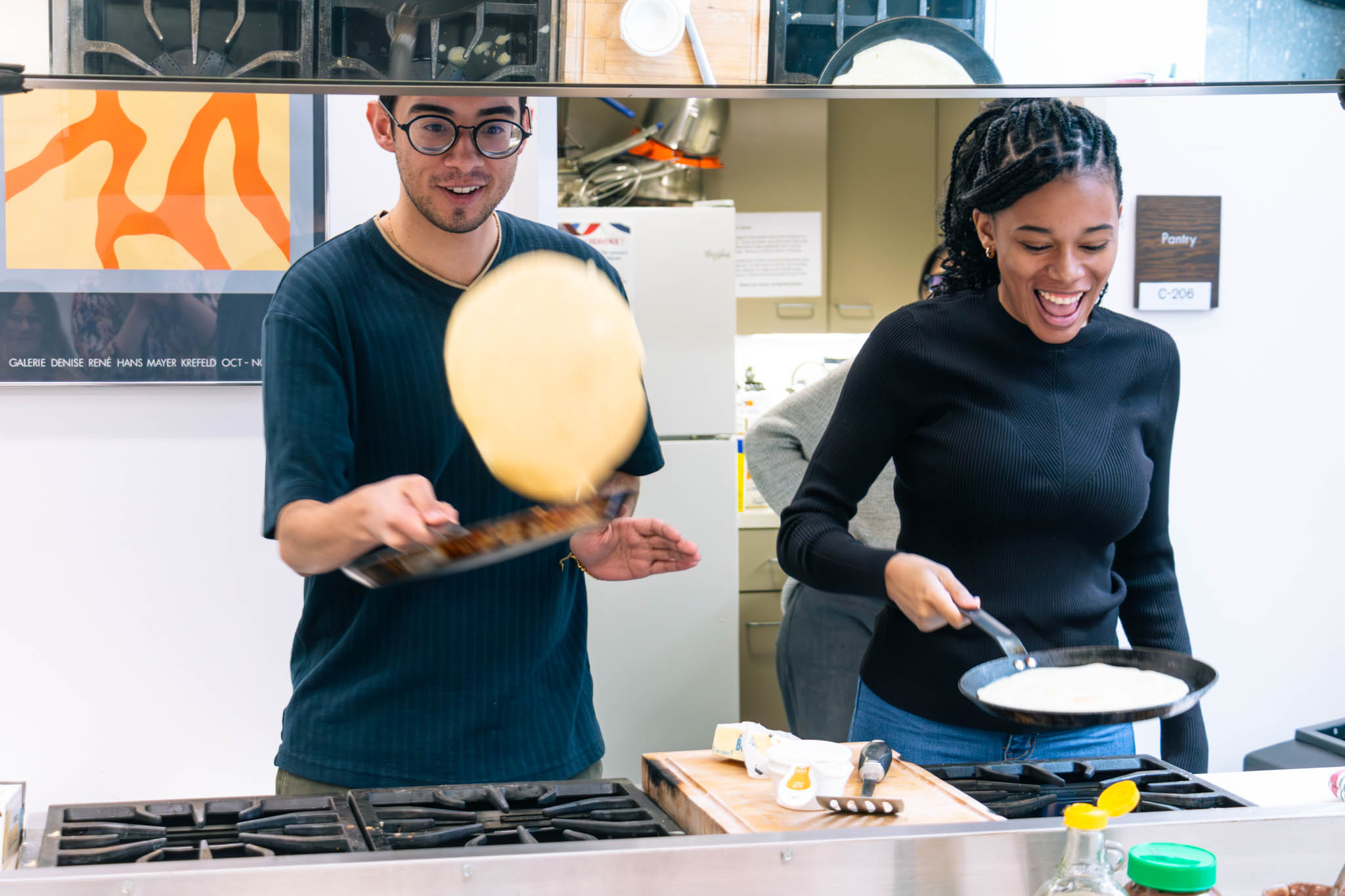 two students practice flipping crepes